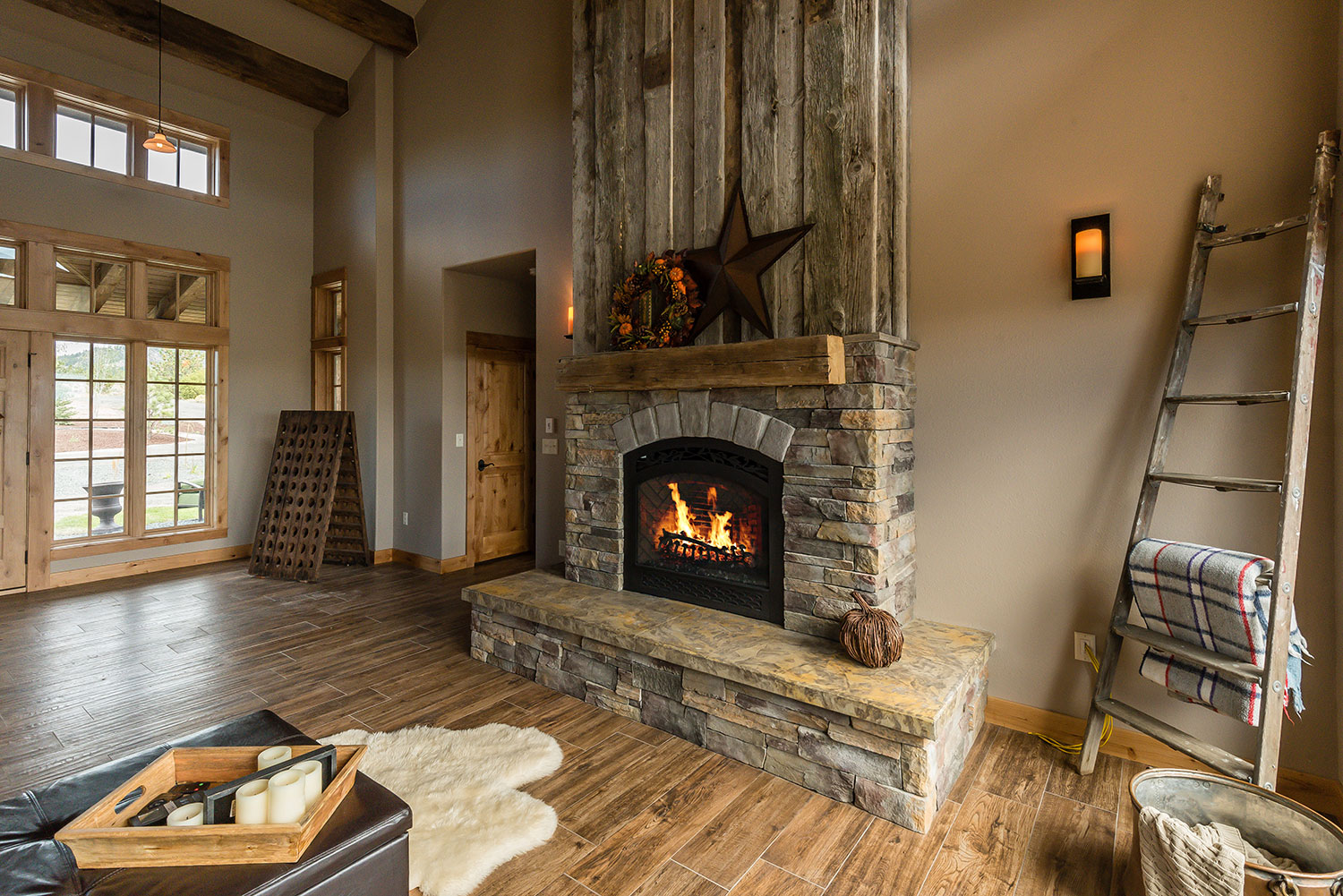 Rock-trimmed fireplace with rustic decor above and around it